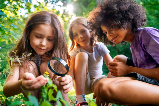 Curious kids exploring the natural world with a magnifying glass