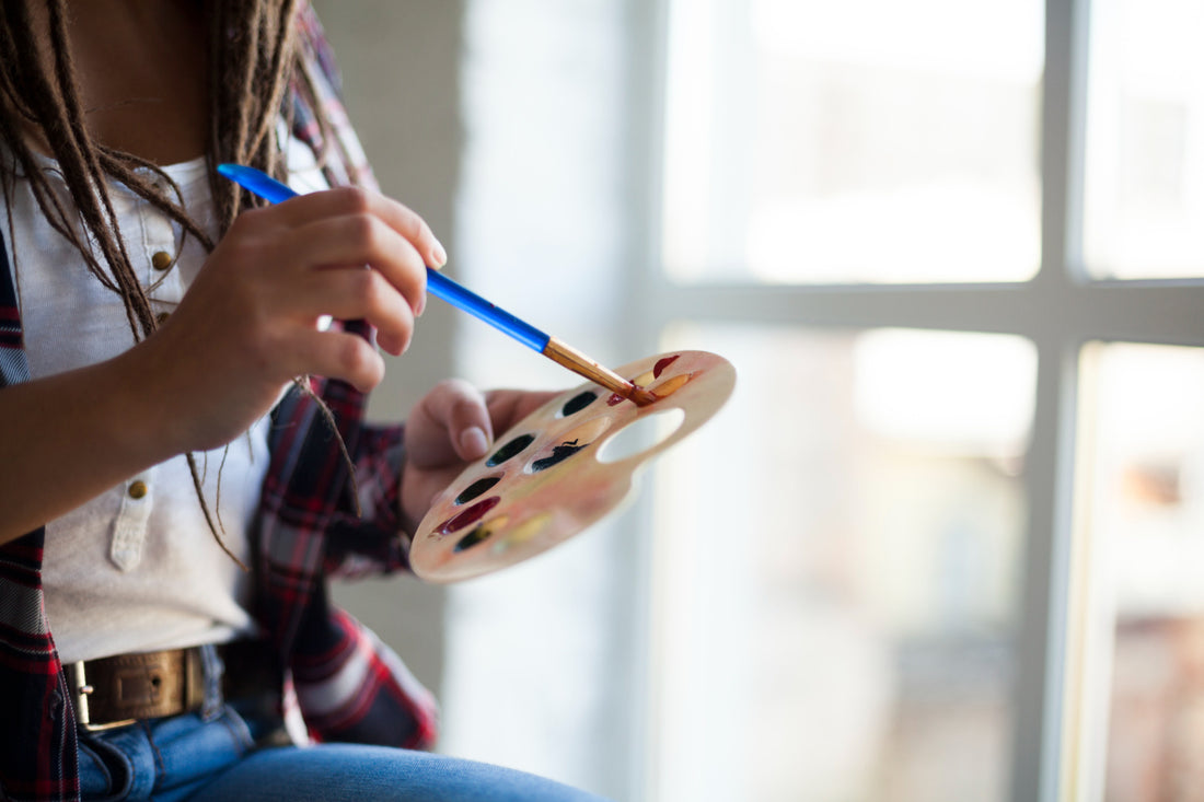 Young artist painting from palette