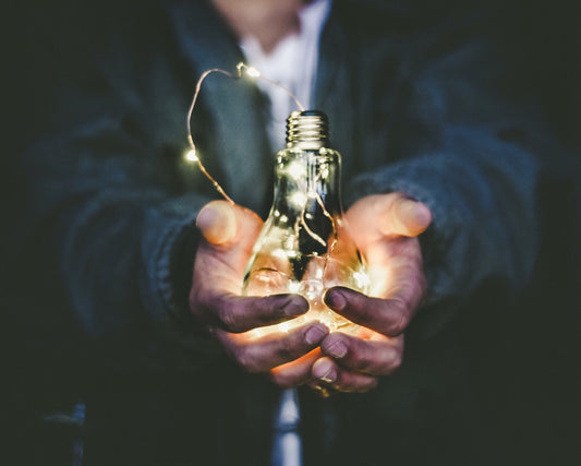 A child holding a lightbulb to show leadership skills in kids.