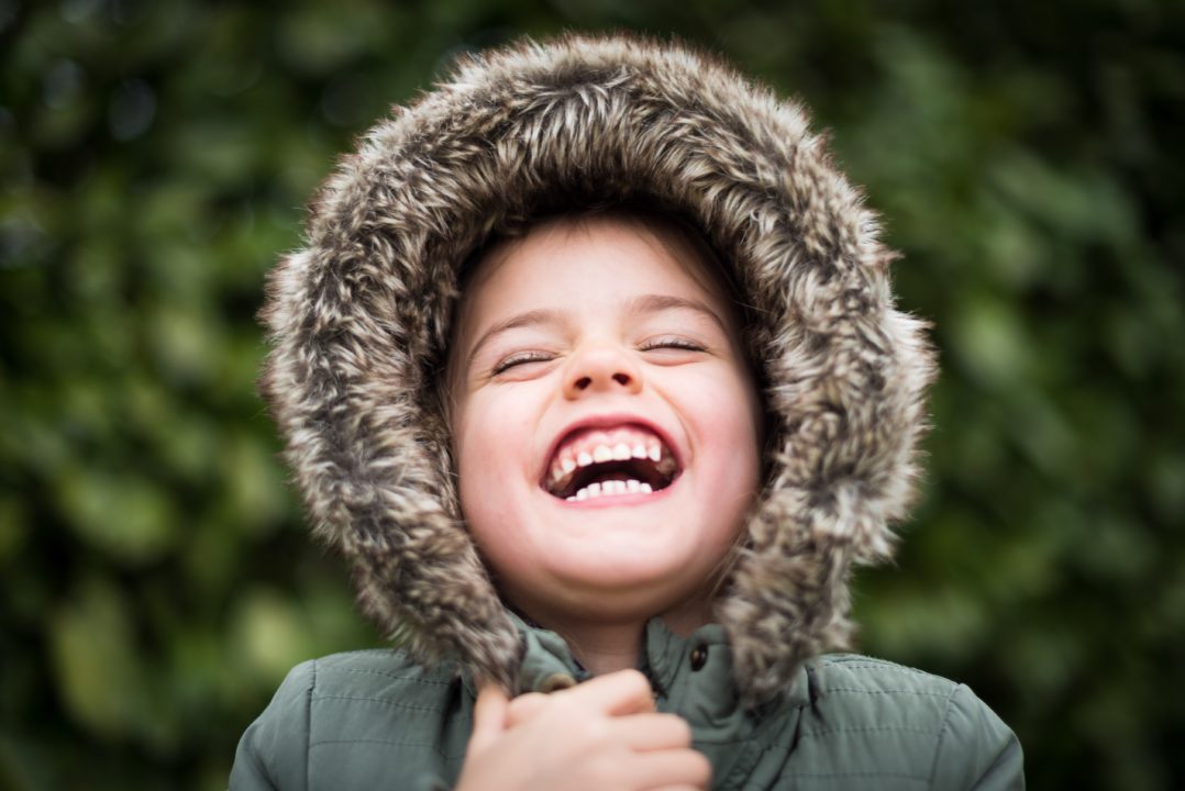Boy in a grey parka laughing